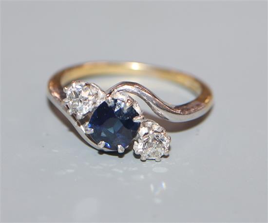 An 18ct, sapphire and diamond three stone crossover ring, size K.